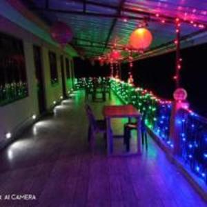 a room with christmas lights and a table and chairs at Little Hut Zelepla Eco Village Retreat by StayApart in Kalimpong