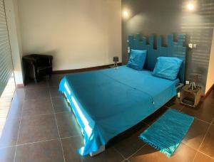a bedroom with a blue bed with a blue comforter at Villa Lanar'am in Bouillante