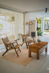 a living room with chairs and a coffee table at Montagne Boutique in Kampot