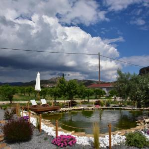 a pond with a bench and an umbrella in a yard at Nafplio Lodge in Nafplio