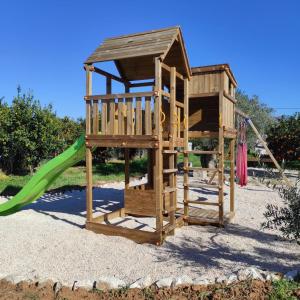 a wooden play set with a slide and a playground at Nafplio Lodge in Nafplio