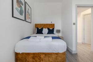 a bedroom with a large bed with white sheets at Dainty 2BD Flat in Greater London in London
