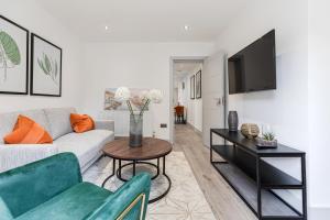 a living room with a couch and a table at Dainty 2BD Flat in Greater London in London