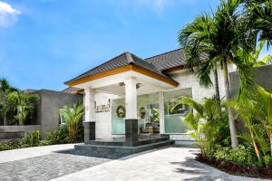 a house with a palm tree in front of it at Le Cielo Romantic Villas by Maviba in Seminyak