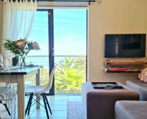 ein Wohnzimmer mit Meerblick in der Unterkunft Apartment18Lifestyle Gordons Bay Beachfront in Gordonʼs Bay