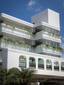 a white building with plants on the balconies at Montagne Boutique in Kampot