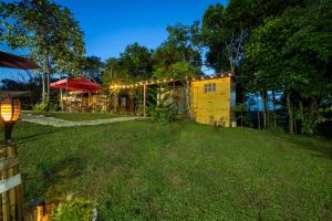 a small yellow house with lights on a yard at Mountain lake Island Cabin Sierra - for family Getaway in Cavinti