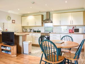 a kitchen with a table and chairs and a television at Uk39800 - Crag Barn in Troutbeck