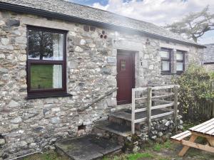 a stone house with a wooden door and stairs outside at Uk39800 - Crag Barn in Troutbeck