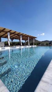 a pool with blue water and a pavilion at Nafplio Lodge in Nafplio