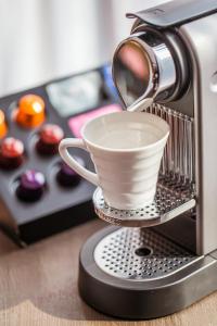 a coffee maker with a cup on a stand at The Langham, Shanghai, Xintiandi in Shanghai