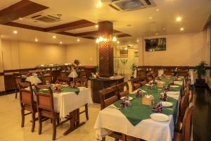 Bharatpur Garden Resort في بهاراتبور: مطعم عليه طاولات وكراسي عليه دمى