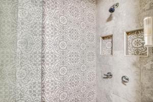a bathroom with a shower with a patterned wall at Close to All, Restful Duplex A in Downtown, UTEP, Hospitals in El Paso