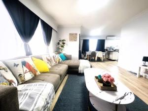 a living room with a couch and a table at LA SOL 1 - All you need for a stay, close to Uni, town & Cambridge in Hamilton