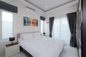 a white bedroom with a white bed and windows at Orchid Paradise Homes OPV428 in Hua Hin +21 photos