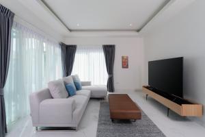 a living room with a couch and a flat screen tv at Orchid Paradise Homes OPV428 in Hua Hin