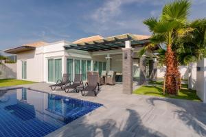 a villa with a swimming pool and a house at Orchid Paradise Homes OPV428 in Hua Hin