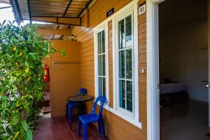 a small porch with two blue chairs and a window at My Home Lantawadee Resort in Ko Lanta