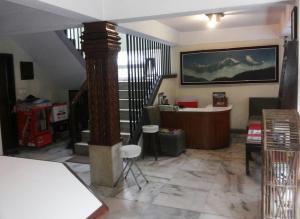 uma sala de estar com uma escada e um quarto com uma mesa em Imperial House em Kathmandu