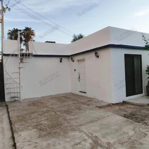 una casa blanca con garaje en Casa Tecalai 5 en San Carlos