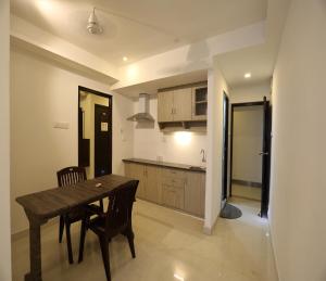 a kitchen and dining room with a wooden table and chairs at Hotel Rydham in Madurai