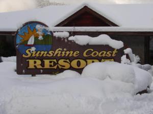 a sign for the sunshine coast resort in the snow at Sunshine Coast Resort in Madeira Park