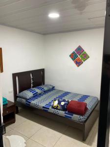 - une chambre dotée d'un lit avec des draps bleus et blancs dans l'établissement Habitación independiente Baño exterior, à Armenia