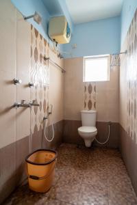 a bathroom with a toilet and a shower and a bucket at Safa Residency in Tiruchchirāppalli