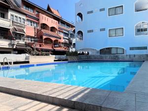 a swimming pool in front of a building at Sunshine Guest House in Hua Hin