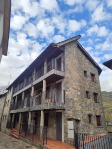 un antiguo edificio de piedra con balcón. en Los Cachorros, en El Pueyo de Jaca