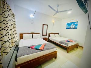una camera da letto con due letti in una stanza di Trinco Star Cabana a Trincomalee