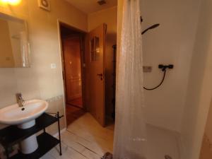 a bathroom with a sink and a shower with a shower curtain at Rajski Staw in Zajki +29 photos