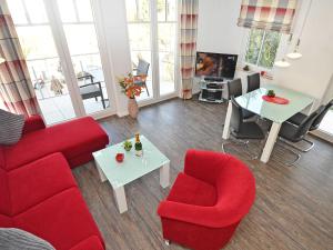 a living room with red furniture and a tv at Villa Rosa - Apt. 05 in Ostseebad Sellin