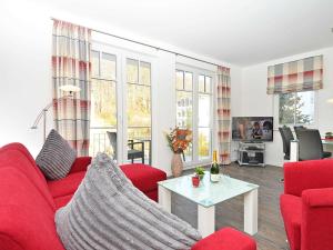 a living room with a red couch and a table at Villa Rosa - Apt. 05 in Ostseebad Sellin
