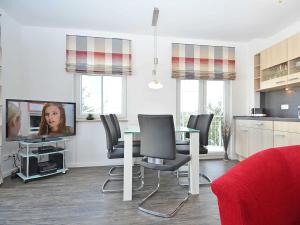 a living room with a table and chairs and a tv at Villa Rosa - Apt. 05 in Ostseebad Sellin