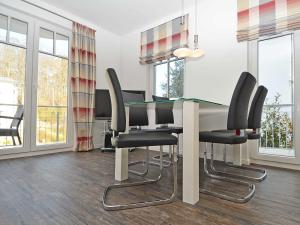 a dining room with a glass table and black chairs at Villa Rosa - Apt. 05 in Ostseebad Sellin +41 photos