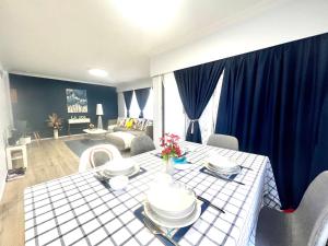 a living room with a table and blue curtains at LA SOL 1 - All you need for a stay, close to Uni, town & Cambridge in Hamilton