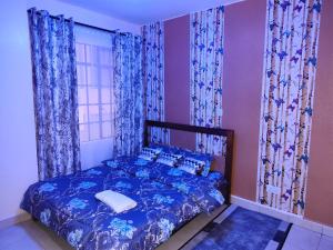 a bedroom with a blue bed with blue curtains at Peace homes in Nairobi