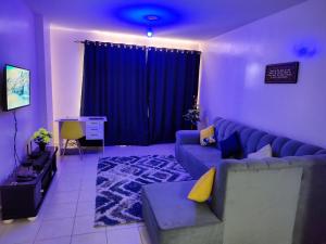 a living room with a blue couch and blue curtains at Peace homes in Nairobi