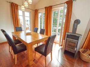 ein Esszimmer mit einem Tisch und einem Holzofen in der Unterkunft Villa Sommerwind - WG 01 mit Sauna, Kamin und Terrasse in Ostseebad Sellin