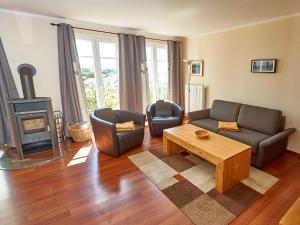 ein Wohnzimmer mit einem Sofa und einem Holzofen in der Unterkunft Villa Sommerwind - WG 02 mit Terrasse, Kamin und Sauna in Ostseebad Sellin