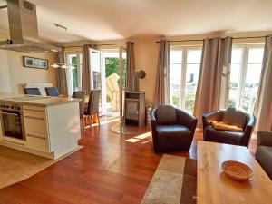 eine Küche und ein Wohnzimmer mit einem Tisch und Stühlen in der Unterkunft Villa Sommerwind - WG 02 mit Terrasse, Kamin und Sauna in Ostseebad Sellin