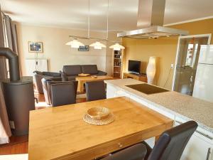 eine Küche und ein Wohnzimmer mit einem Holztisch in der Unterkunft Villa Sommerwind - WG 02 mit Terrasse, Kamin und Sauna in Ostseebad Sellin
