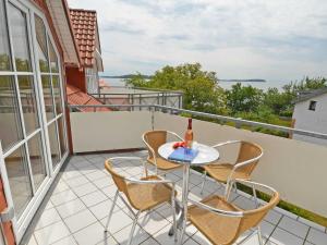 eine Terrasse mit einem Tisch und Stühlen auf dem Balkon in der Unterkunft Villa Vilmblick - Wohnung 23 mit Meerblick-Balkon in Lauterbach
