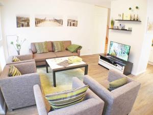 a living room with a couch and a table at Strandvilla Baabe - Maisonette "Sonnenwiege" mit Sauna und Whirlpool in Baabe +15 photos