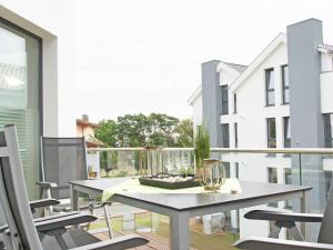 einen Balkon mit einem Tisch und Stühlen auf einem Gebäude in der Unterkunft Strandvilla Baabe - Maisonette "Sonnenwiege" mit Sauna und Whirlpool in Baabe