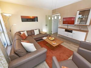 uma sala de estar com um sofá e uma televisão em Strandvilla Baabe F 635 WG 11 "Bernstein" mit Meerblick, Kamin, Sauna em Baabe
