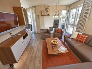 a living room with a large flat screen tv at Strandvilla Baabe F 635 WG 11 "Bernstein" mit Meerblick, Kamin, Sauna in Baabe