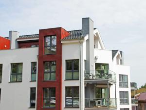 ein Apartmenthaus in Rot und Weiß in der Unterkunft Strandvilla Baabe - Maisonette "Sonnenwiege" mit Sauna und Whirlpool in Baabe