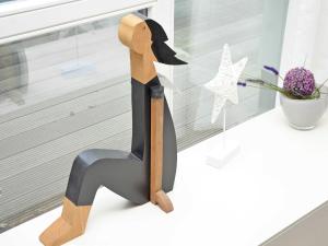 a wooden statue of a woman sitting on a table next to a window at Strandvilla Baabe - Ferienwohnung 16 mit Sauna in Baabe +17 photos